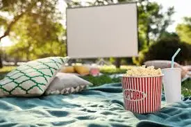 a popcorn in a bucket on a blanket